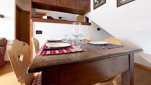 Une table de salle à manger en bois, mise avec des assiettes, des verres et un set de table.
