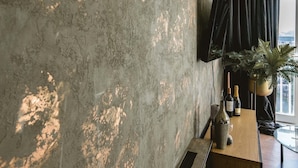 Ein modernes Interieur mit einer strukturierten Wand, einer Holztheke und einem Blumentopf.