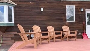 A wooden deck with four Adirondack chairs and a red door. - Slate View, Riverbend, Garage, Fishing, Hot Tub! (Crested Butte)