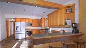 A kitchen with wooden cabinets, a stainless steel refrigerator, an oven, a microwave, and a coffee maker. - Slate View, Riverbend, Garage, Fishing, Hot Tub! (Crested Butte)