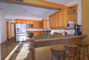 A kitchen with wooden cabinets, a stainless steel refrigerator, an oven, a microwave, and a coffee maker. - Slate View, Riverbend, Garage, Fishing, Hot Tub! (Crested Butte)