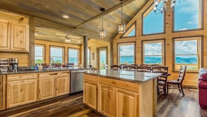 Una cocina amplia con armarios de madera, una isla grande y varias ventanas con vistas al exterior.