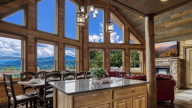 Una cocina amplia con una isla grande, armarios de madera y una chimenea de piedra.