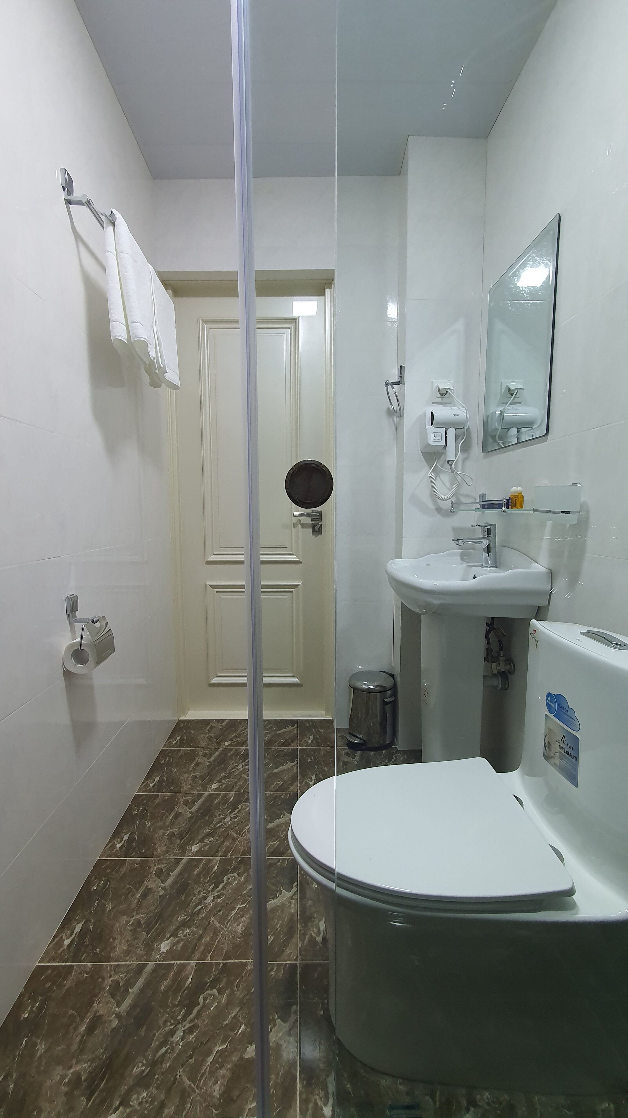 Een badkamer met toilet, wastafel en douche.
