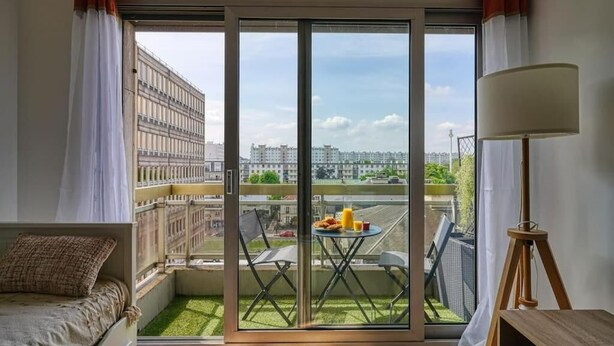A balcony with a table, chairs, and a view of buildings. - ''diamant'' (Choisy-le-Roi)