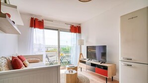 A modern living room with a sofa, TV, and a dining area with a table and chairs. - ''diamant'' (Choisy-le-Roi)