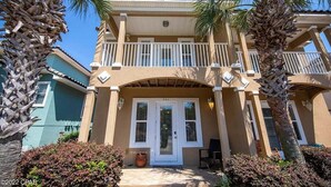 A two-story building with a balcony, a front door, and a small porch area. - 3 mins walk to Beach! Guest Beachfront Pool! (Panama City Beach)