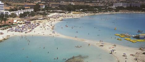 Una playa cerca, sillas reclinables de playa, toallas de playa