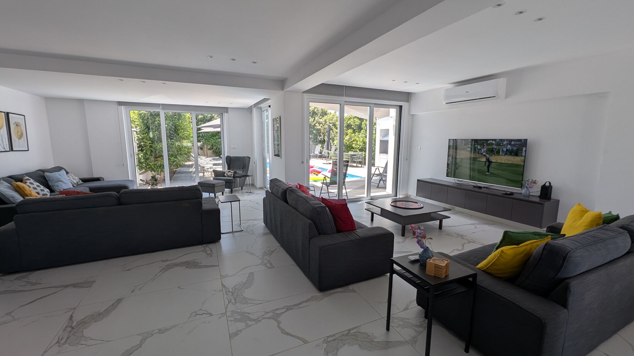 Una sala moderna con un sofá modular, una mesa de centro y un televisor.