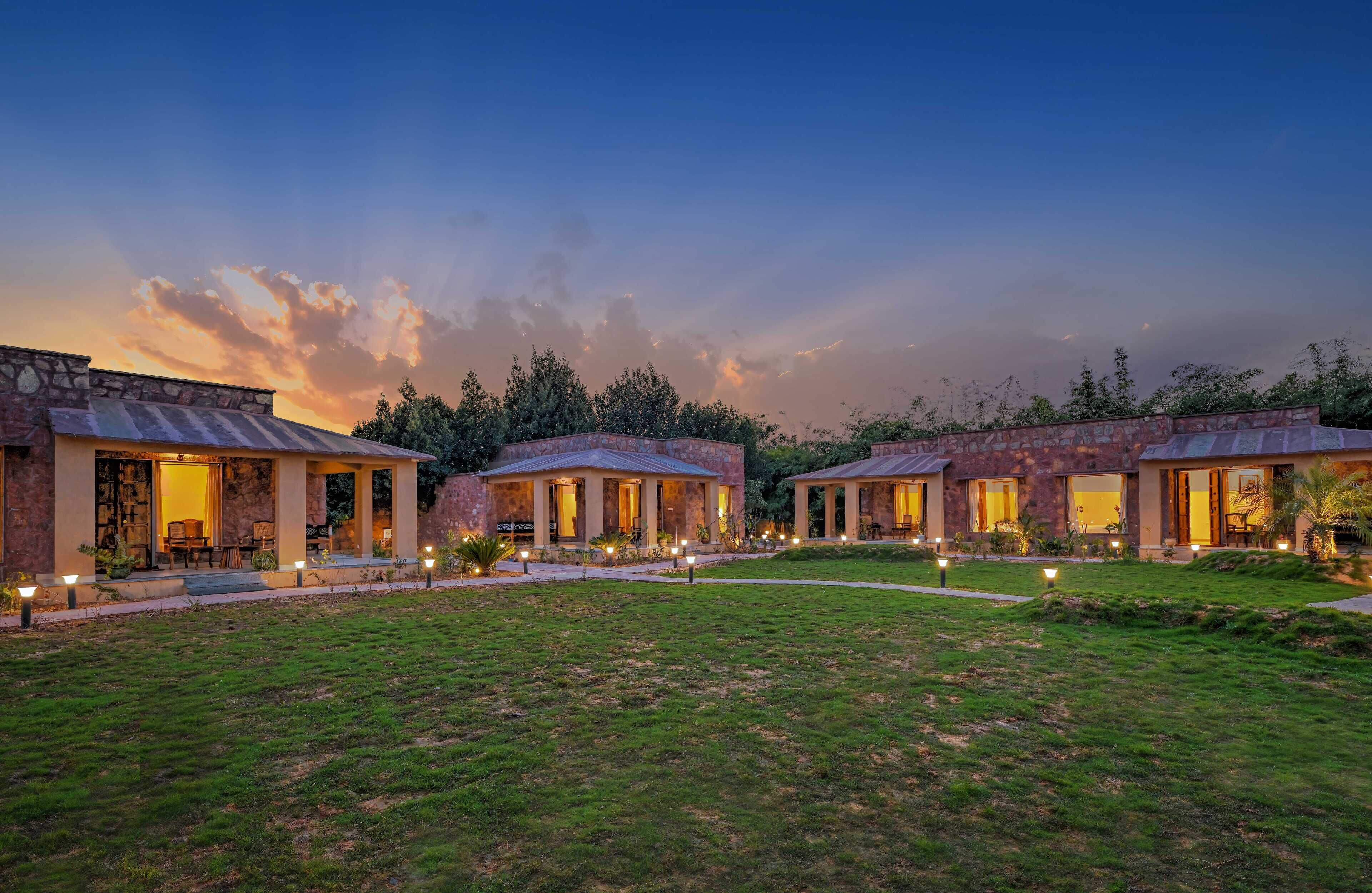 A modern resort with stone buildings, outdoor seating, and well-lit pathways.