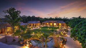 A resort with multiple villas, a central courtyard, and a small pond.