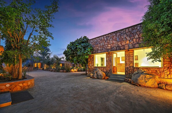 A stone building with large windows and a paved driveway. - Aranya Vilas, Ranthambhore (Sawai Madhopur)