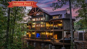 Ein mehrstöckiges Lodgehaus mit einem großzügigen Innenpool, umgeben von Bäumen.