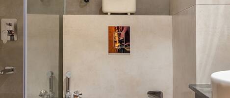 Un baño moderno con cabina de ducha de vidrio, inodoro, lavamanos y una planta en maceta.