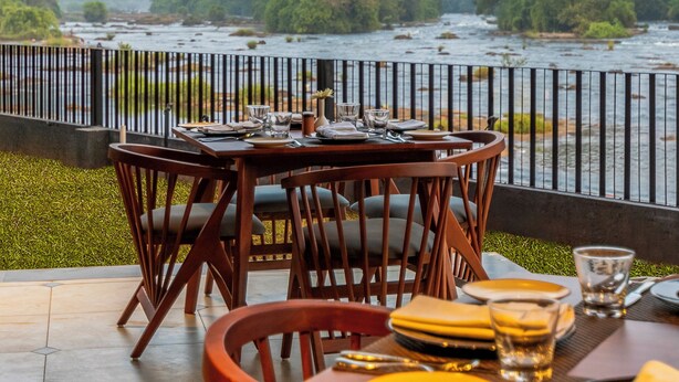 Un comedor con vista a un río y un bosque.
