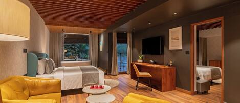 A modern hotel room with a wooden ceiling, a bed, a desk, a TV, and a seating area with yellow chairs.
