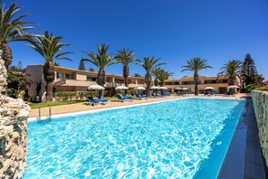 Een buitenzwembad, parasols voor strand/zwembad