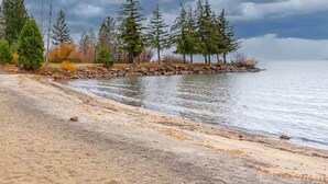 Une plage bordée d’arbres et dont le rivage est rocheux.