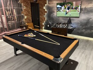 Enjoy a game of pool or foosball in this cozy room with a pool table and foosball table.