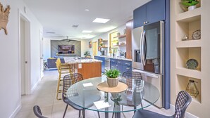 A modern kitchen with blue cabinets, a glass dining table, and a ceiling fan. - Charming Tucson Vacation Rental: 2 Mi to Downtown (Tucson)