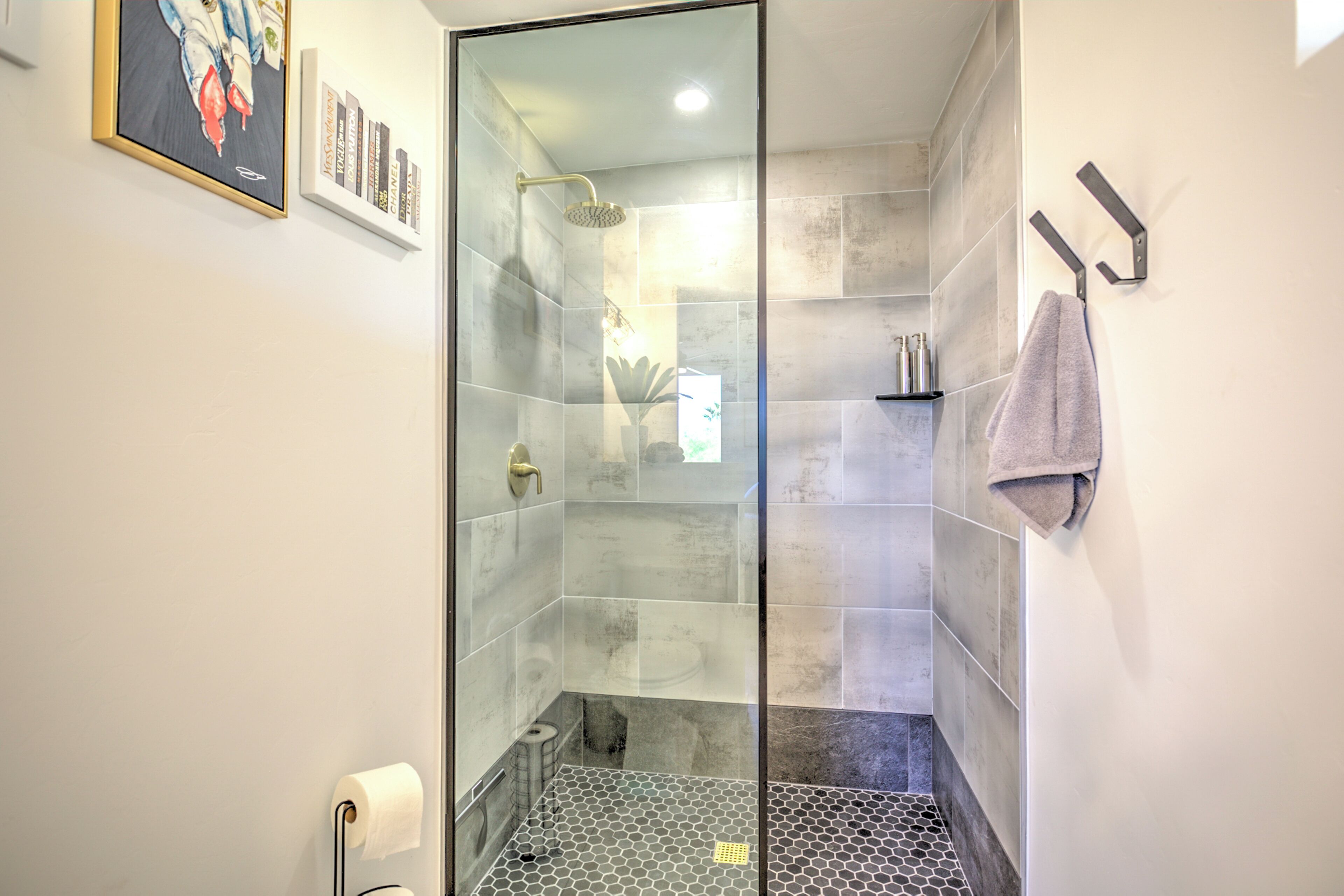 Un bagno moderno con box doccia in vetro, un water e un porta asciugamani.