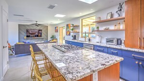 A modern kitchen with a large island, bar stools, and blue cabinets. - Charming Tucson Vacation Rental: 2 Mi to Downtown (Tucson)