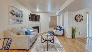 A living room with a sofa, coffee table, and a fireplace. - Colorado Springs Townhome ~ 7 Mi to Downtown! (Colorado Springs)
