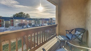 A balcony with a view of a residential area, a chair, and a table. - Colorado Springs Townhome ~ 7 Mi to Downtown! (Colorado Springs)