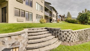 A multi-story building with a stone staircase leading to a grassy area.