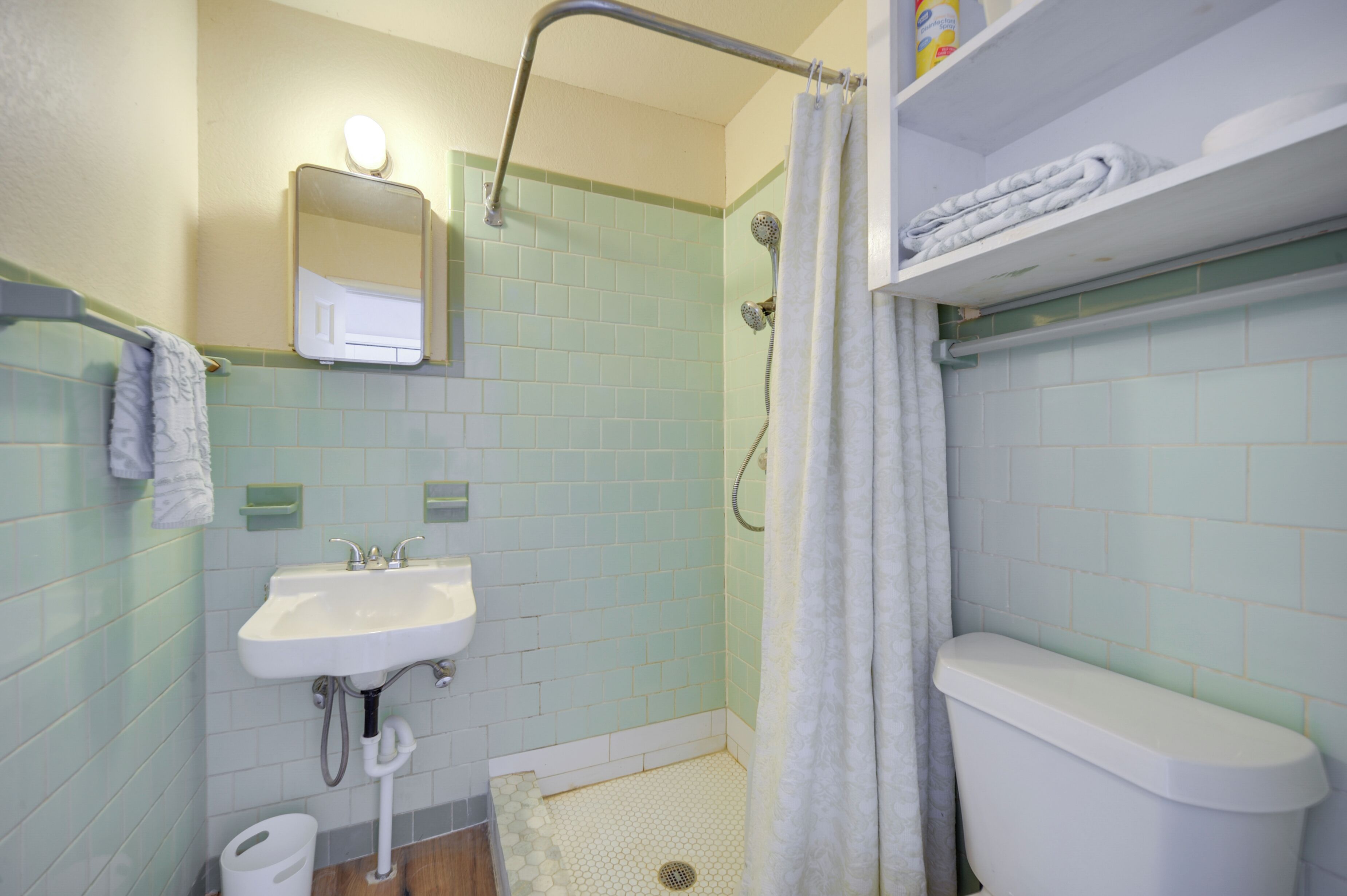 Ein Badezimmer mit Waschbecken, Toilette, Dusche und Spiegel.