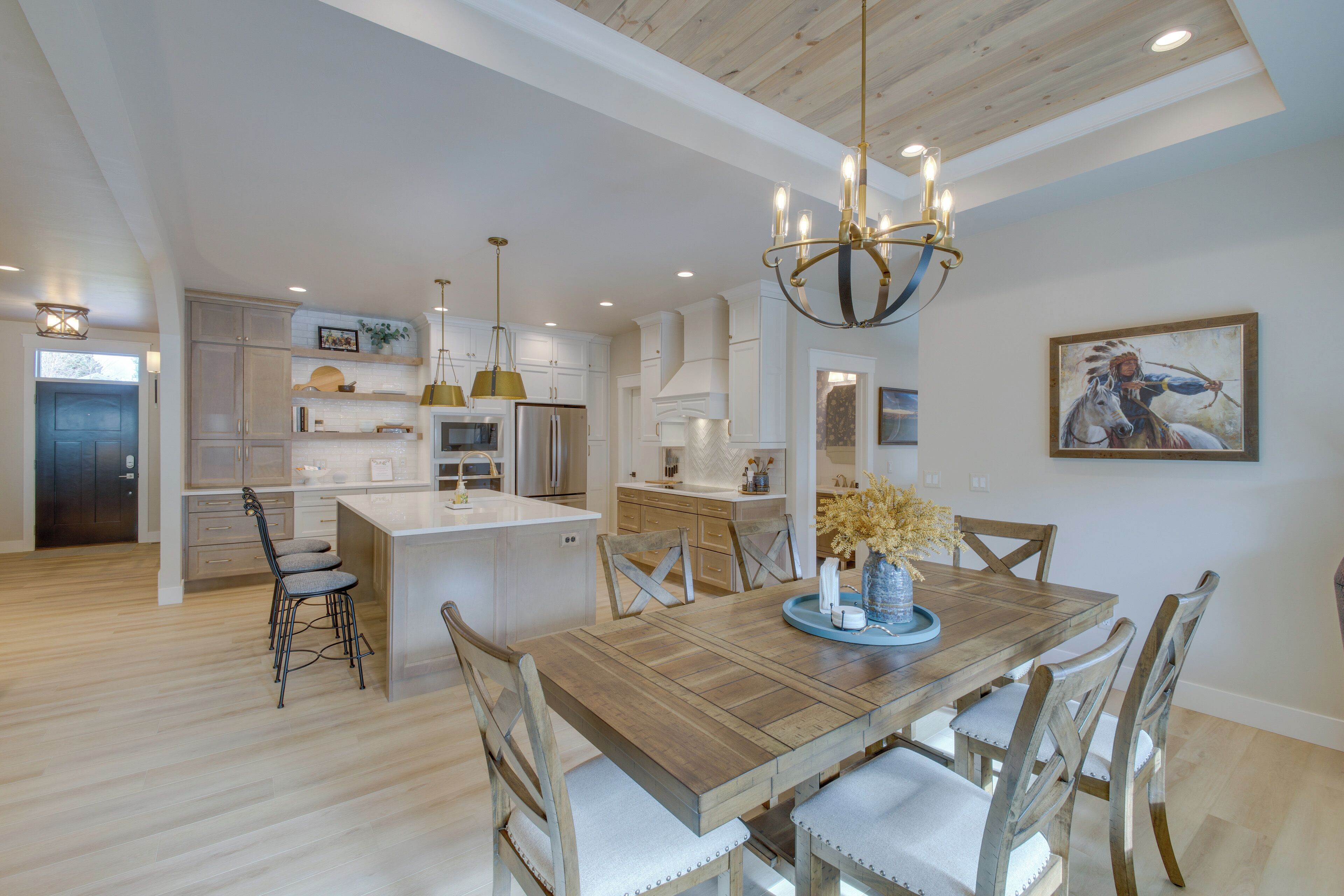 Una cocina amplia con una isla central, una mesa de comedor de madera y sillas.