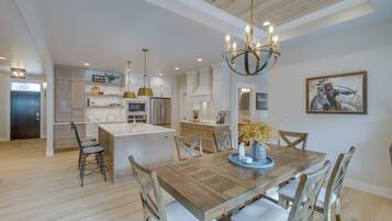 Una cocina amplia con una isla central, una mesa de comedor de madera y sillas.
