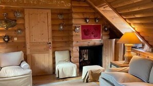 A log cabin interior with a cozy seating area, a fireplace, and wooden walls. - Appartement D'exception Type Chalet Avec vue sur les Toits Saint Honoré / Louvre (Paris)