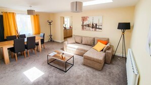 A modern living room with a sofa, coffee table, and dining area. - Charming 2-bed Apartment in Stroud (Stroud)
