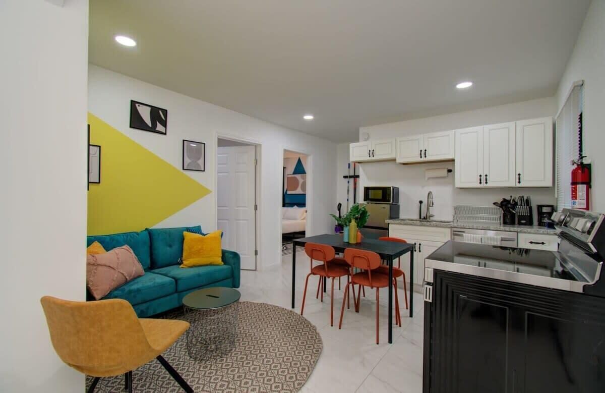 A modern apartment with a living room, dining area, and kitchen.