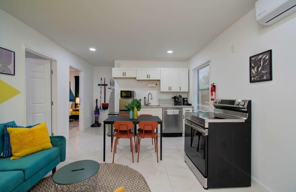 A compact living space with a kitchenette, a dining area, and a sofa.