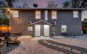 A two-story building with a front porch, outdoor seating, and a satellite dish.