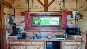Una cocina compacta con un lavamanos, un microondas y un refrigerador.