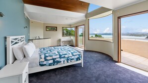 Un dormitorio con cama, escritorio y un amplio ventanal que ofrece vistas al exterior.