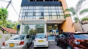A building with a storefront, a sign for 'SK Jewellers', and parked cars in front. - White House 101 (Galle)
