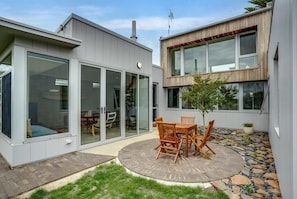 A modern house with a patio, a dining area, and a large window.