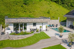 A modern house with a swimming pool, a patio with seating, and a well-maintained lawn. - Wellness Resort Trebnje (Trebnje)