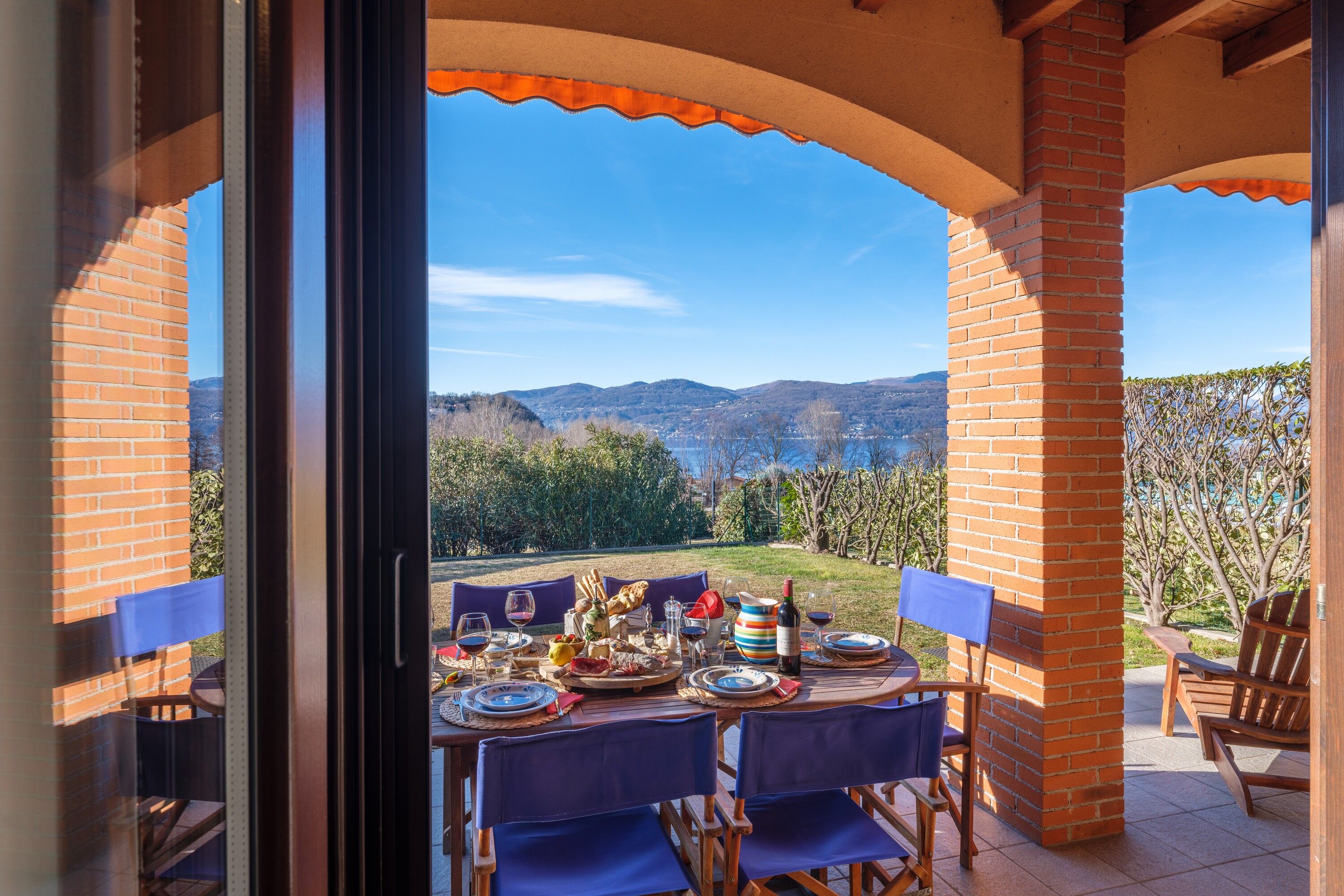 Un espace de restauration en plein air avec une table dressée pour quatre personnes, offrant une vue sur un paysage montagneux.