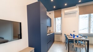 Eine moderne Küche mit Einbauofen, Essbereich mit Tisch und Stühlen sowie ein großes Fenster mit Aussicht.