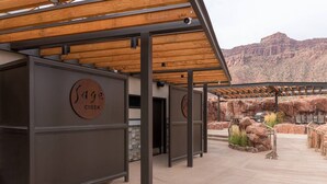 Un espace extérieur abrité, doté d’un plafond en bois et de murs en métal, sur lequel on peut lire l’inscription « Sage Creek ».