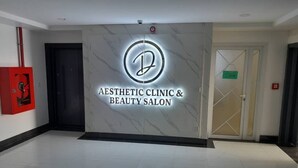 A reception area with a marble wall and a logo for 'Aesthetic Clinic & Beauty Salon'. - WAAFI CITY CENTER RESIDENCE (Djibouti)