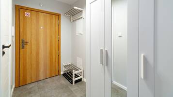 A hallway with a wooden door, a white radiator, and a white wardrobe.