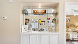 A reception area with a glass display case, a welcome sign, and a thermostat on the wall. - TB 19H Par tee Updated and spacious three bedroom condo in True Blue (Pawleys Island)