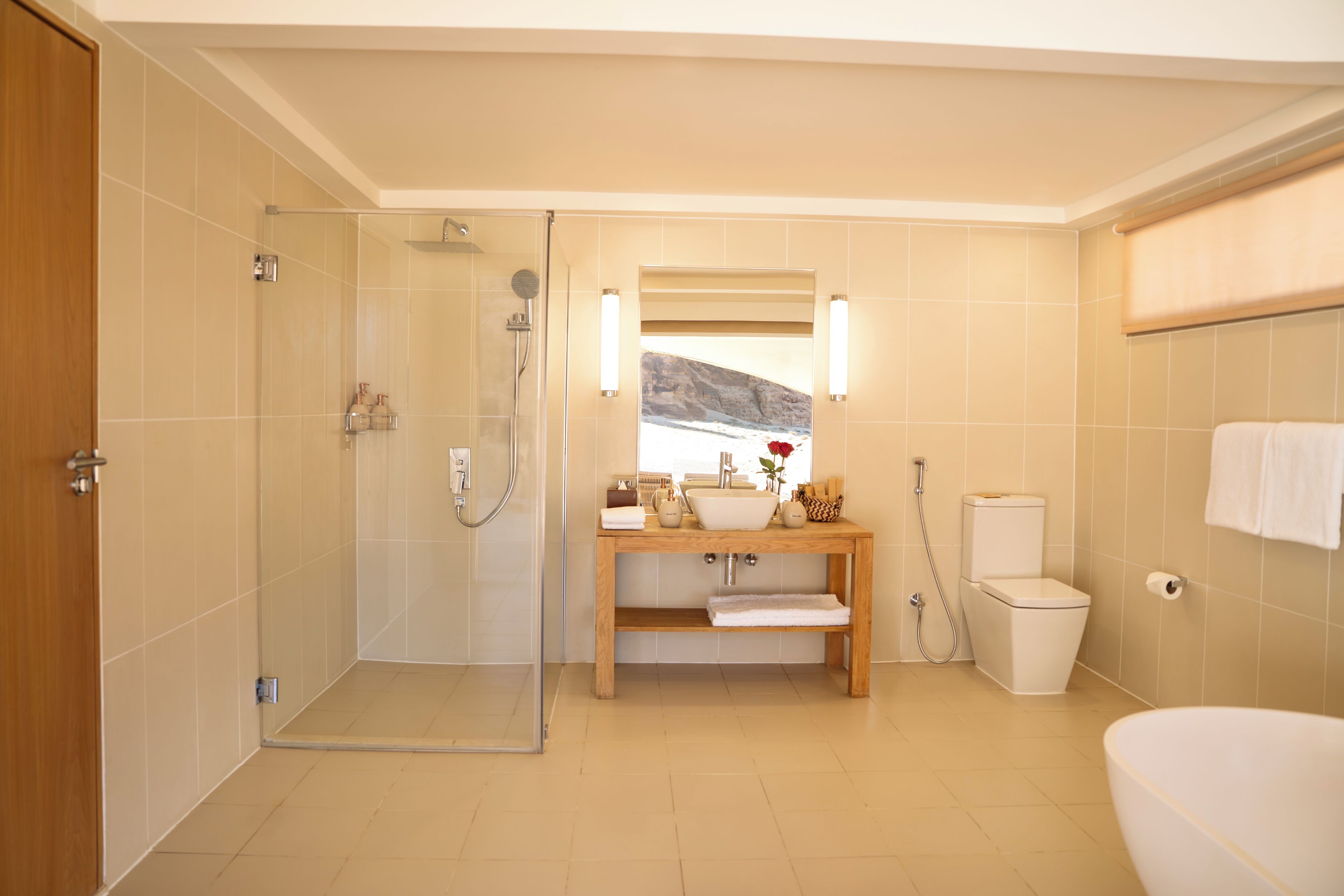 A modern bathroom with a glass shower enclosure, a wooden vanity with a sink, and a toilet.
