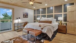 A bedroom with a bed, a desk, a chair, a bench, and a cowhide rug. - Summer Getaway!! Nearby attractions including Dollywood!! (Sevierville)